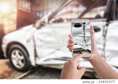 smart phone to take a photo of the damage by a car 34845477