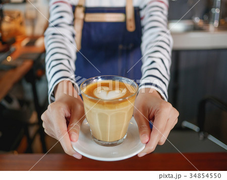Asian young woman holding hot cup of coffee. Asian young woman holding hot cup of coffee. 34854550