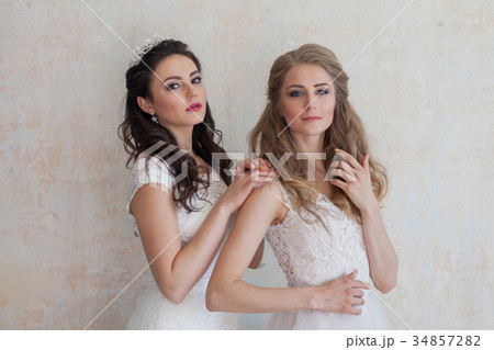 two girls in white dresses brunette and blonde 34857282