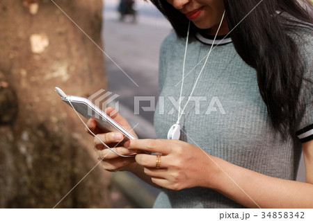 スマートホンで音楽を聴く若い女性 34858342