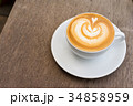 A white cup of coffee latte art on wood table 34858959