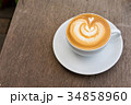 A white cup of coffee latte art on wood table 34858960