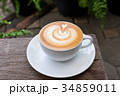A white cup of coffee latte art on wood table 34859011