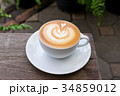 A white cup of coffee latte art on wood table 34859012
