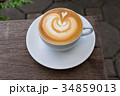 A white cup of coffee latte art on wood table 34859013