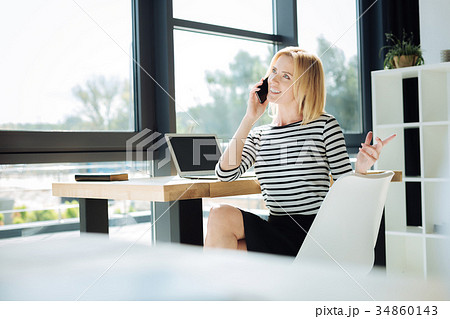 Attractive confident businesswoman talking on the 34860143