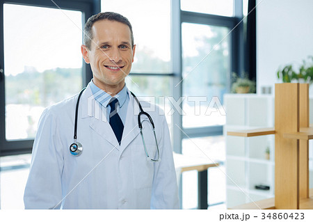 Positive nice man standing in his office Positive nice man standing in his office 34860423