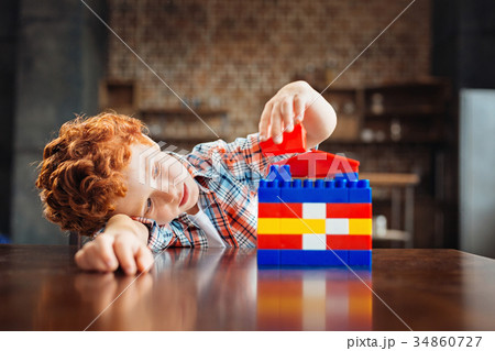 Pensive little kid playing with construction set 34860727