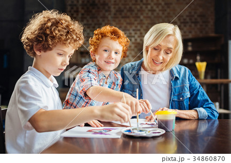 Cute ginger haired boy enjoying painting with Cute ginger haired boy enjoying painting with 34860870
