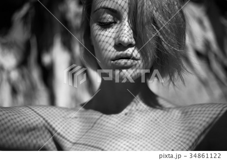Lady with fishnet pattern on face 34861122