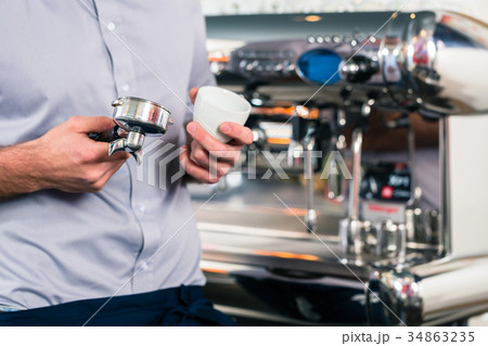 Waiter preparing espresso at an automatic coffee 34863235
