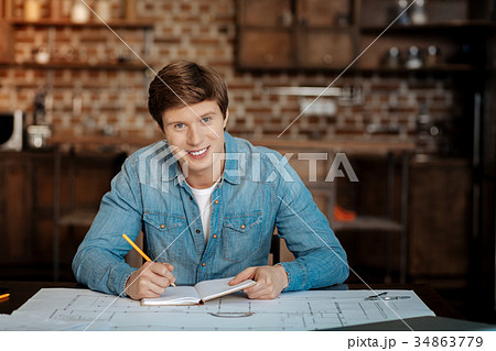Handsome man posing while doing project Handsome man posing while doing project 34863779