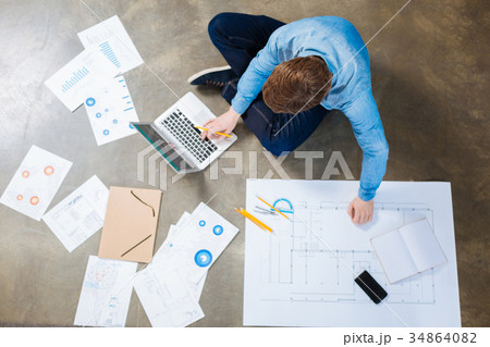 Top view of brown-haired engineer working on the Top view of brown-haired engineer working on the 34864082
