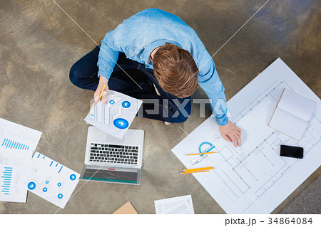 Top view of engineer studying charts and blueprint Top view of engineer studying charts and blueprint 34864084