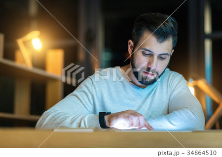 Delighted male person playing with tablet 34864510