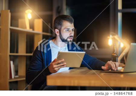 Serious male person using his gadgets Serious male person using his gadgets 34864768