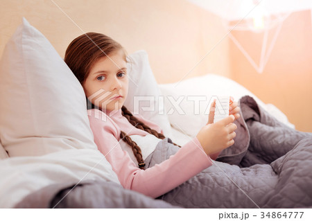 Sad little child sitting with a pillbox 34864777