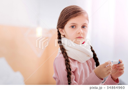 Cute girl with big grey eyes holding a thermometer 34864960