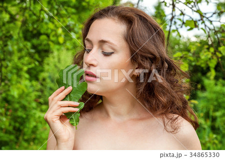 Girl with the leaf in her hand in a park 34865330