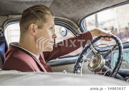 Blond man driving vintage car 34865637
