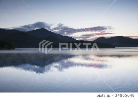 USA, New York, Silhouette of mountains with Lake Placid in foreground at sunrise USA, New York, Silhouette of mountains with Lake Placid in foreground at sunrise 34865649