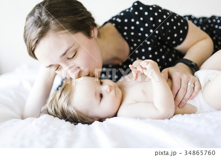 Baby girl (6-11 Months) being kissed by mother 34865760