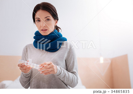 Curious woman standing with a little pillbox 34865835