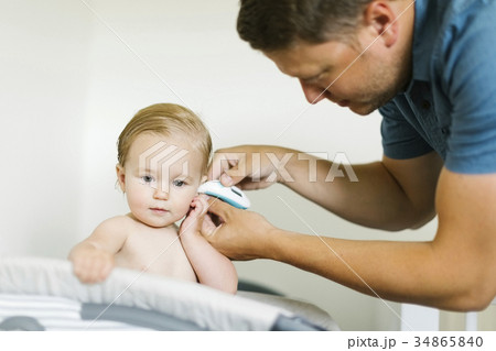Father measuring temperature to baby girl (12-17 months) Father measuring temperature to baby girl (12-17 months) 34865840