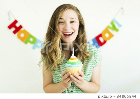 Mid adult woman blowing birthday candle 34865844