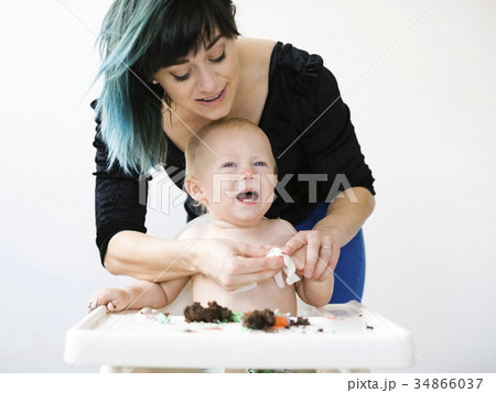 Mother cleaning baby boy (12-17 months) from cupcake Mother cleaning baby boy (12-17 months) from cupcake 34866037