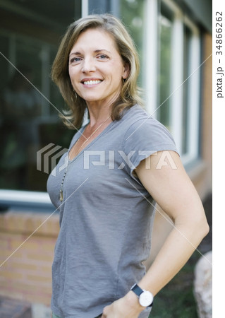 Portrait of smiling woman in front of house Portrait of smiling woman in front of house 34866262