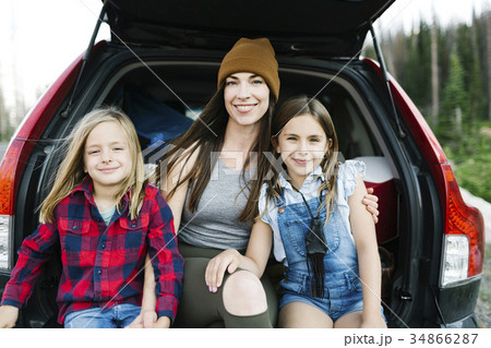 Portrait of woman with son (6-7) and daughter (8-9) in back of car 34866287