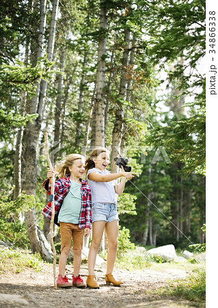 Girl (8-9) and boy (6-7) standing in forest 34866338
