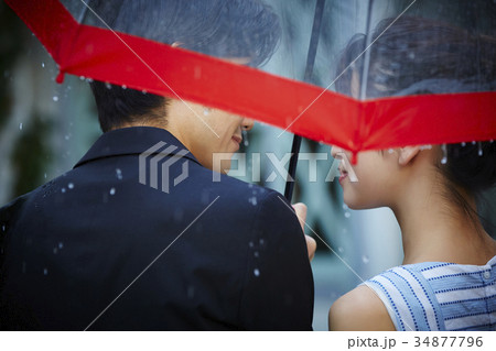 雨の中を歩くカップル 34877796
