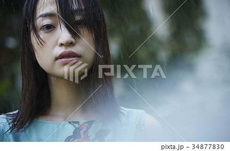 雨に打たれる女性の写真素材