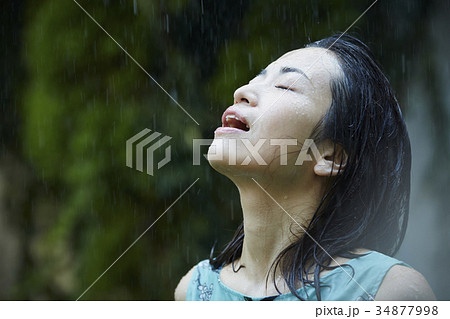 雨に打たれる女性の写真素材