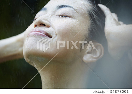 雨に打たれる女性の写真素材