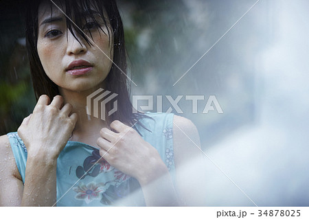 雨に打たれる女性の写真素材