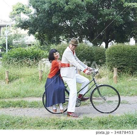 自転車に乗るシニアカップルの写真素材