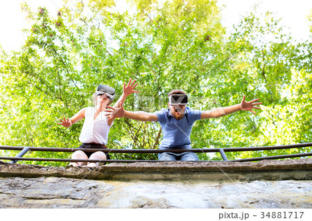 Couple with VR goggles on a walk in town. Couple with VR goggles on a walk in town. 34881717