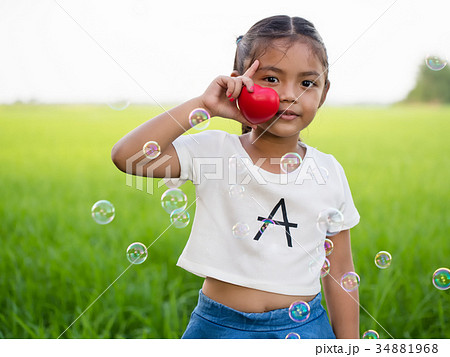 Portrait of little asian girl holding red heart. 34881968