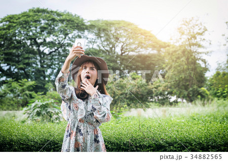 Attractive asian woman Take a photo and relaxing at the park Attractive asian woman Take a photo and relaxing at the park 34882565