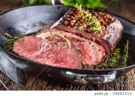 Juicy medium beef Rib Eye steak slices in pan. 34883314
