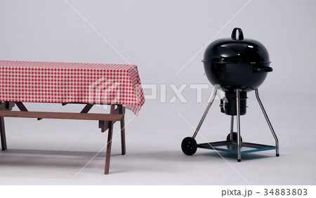 Table with red napkin and BBQ stove. Table with red napkin and BBQ stove. 34883803