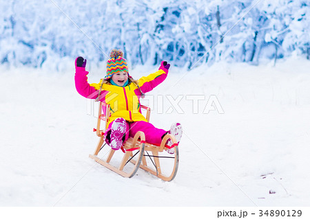 Kids play in snow. Winter sleigh ride for children Kids play in snow. Winter sleigh ride for children 34890129