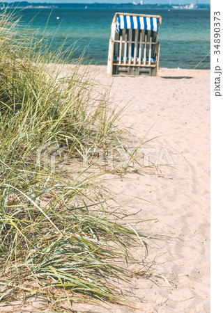 Sand dune with grass and blue colored roofed 34890373