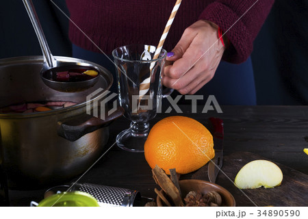 female hands pouring hot mulled wine female hands pouring hot mulled wine 34890590