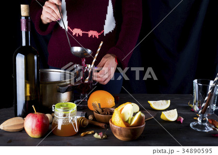 female hands pouring hot mulled wine 34890595