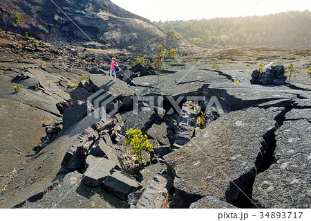 Young female tourist exploring surface of the Kilauea Iki volcano crater Young female tourist exploring surface of the Kilauea Iki volcano crater 34893717