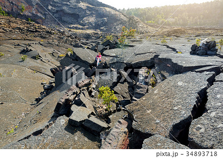 Young female tourist exploring surface of the Kilauea Iki volcano crater Young female tourist exploring surface of the Kilauea Iki volcano crater 34893718